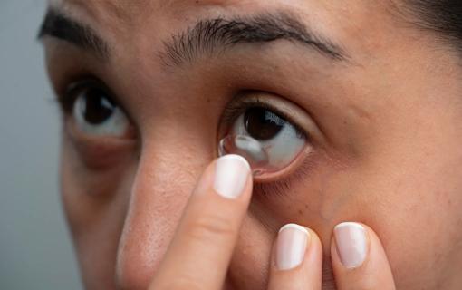 Person inserting contact into eye