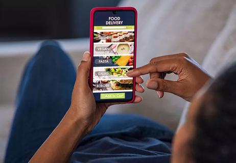 Person making a selection from a food delivery app on their phone.