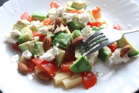 Plate of avocado, tomato, cheese and almond salad